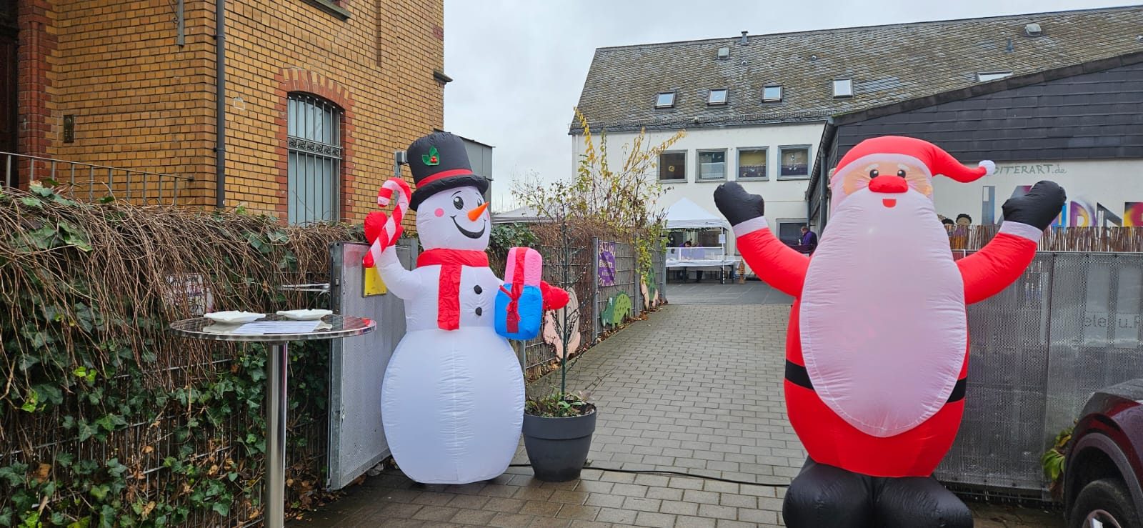 Aufblasbarer Schneemann und Weihnachtsmann beim Adventsglühen